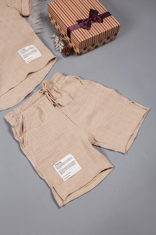 طقم ولادي قطعتين لون بيج أكمام قصيرة بياقة وأزرار قفل وطبعات من الامام وشورت بجيوب و رباط من الخصر