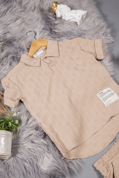 طقم ولادي قطعتين لون بيج أكمام قصيرة بياقة وأزرار قفل وطبعات من الامام وشورت بجيوب و رباط من الخصر