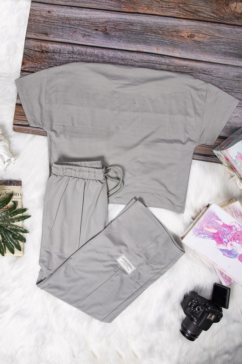 طقم نسائي أنيق قطعتين تي شيرت أكمام قصيرة بكتابات وجيوب من الأمام و بنطلون برباط على الخصر