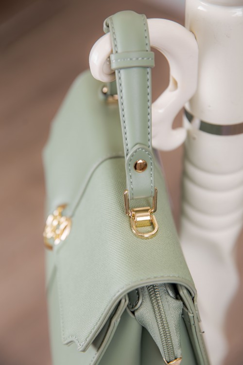 حقيبة يد نسائية لون أخضر مزينة بميدالية مع حمالة للكتف