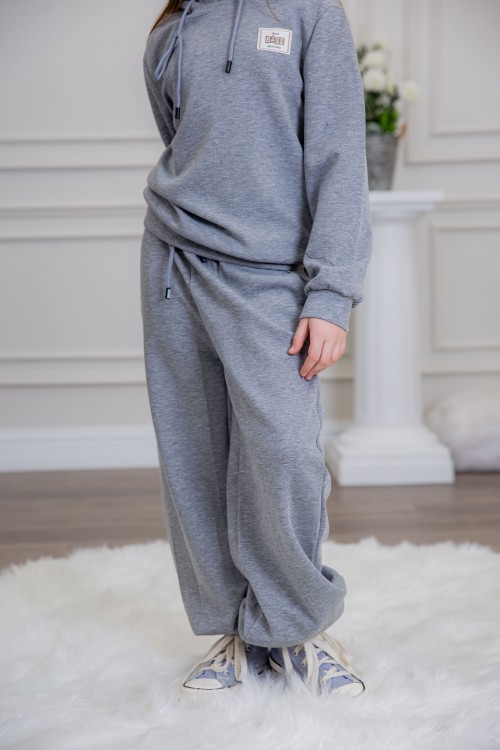 طقم بناتي أنيق قطعتين لون رمادي مع قبعة هودي و أكمام طويلة مع كتابة أمامية و بنطلون بجيوب و مطاط من الأسفل