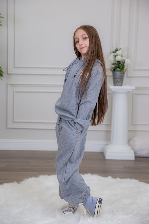 طقم بناتي أنيق قطعتين لون رمادي مع قبعة هودي و أكمام طويلة مع كتابة أمامية و بنطلون بجيوب و مطاط من الأسفل