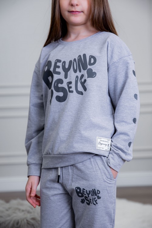 طقم بناتي أنيق قطعتين لون رمادي أكمام طويلة مع كتابة أمامية و بنطلون بجيوب و مطاط من الأسفل