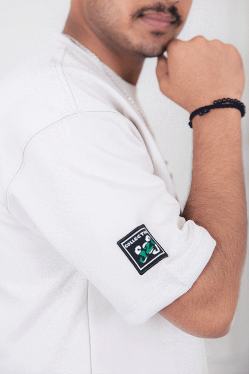 تيشيرت رجالي لون أبيض أكمام قصيرة مزين برسومات و كتابات من الأمام