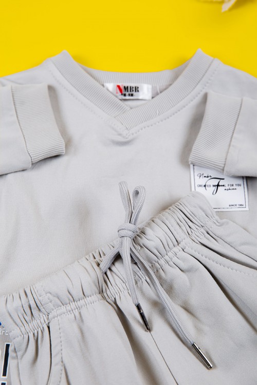 طقم بناتي شتوي قطعتين لون رصاصي بكتابات من الأمام و أكمام طويلة و رباط و زم من الخصر