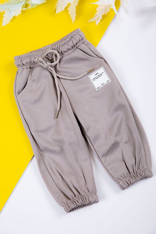 طقم بناتي شتوي قطعتين لون بيج بكتابات من الأمام و بقبعة رأس  و أكمام طويلة و رباط و زم من الخصر