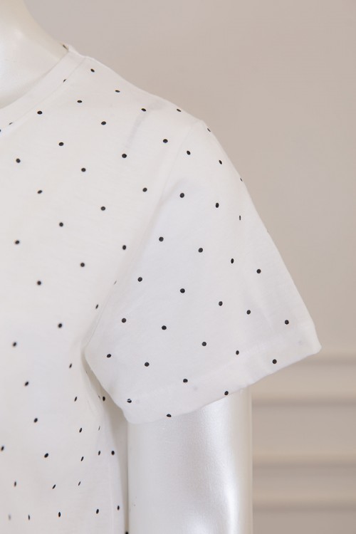 قميص نسائي طويل لون أبيض منقط بكتابة من الأمام و بياقة دائرية ذو أكمام قصيرة