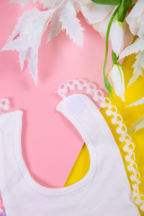 مريلة أطفال لون أبيض برسومات من الأمام و بأطراف من الدانتيل