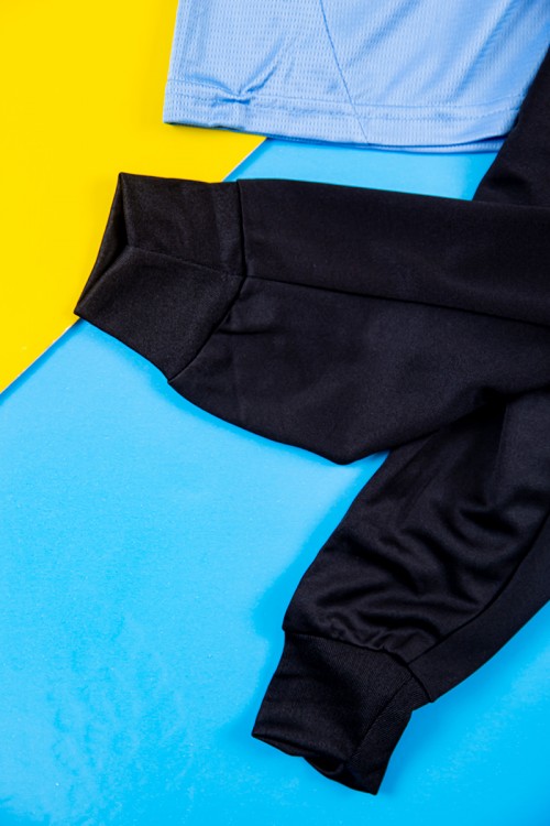 طقم ولادي رياضي قطعتين تيشيرت مانشستر سيتي بأكمام قصيرة و بنطلون طويل لون أسود مخطط باللون السماوي من الجانبين بزم من الخصر و الأسفل