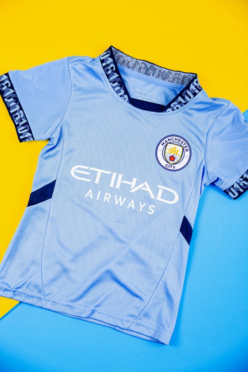 طقم ولادي رياضي قطعتين تيشيرت مانشستر سيتي بأكمام قصيرة و بنطلون طويل لون أسود مخطط باللون السماوي من الجانبين بزم من الخصر و الأسفل