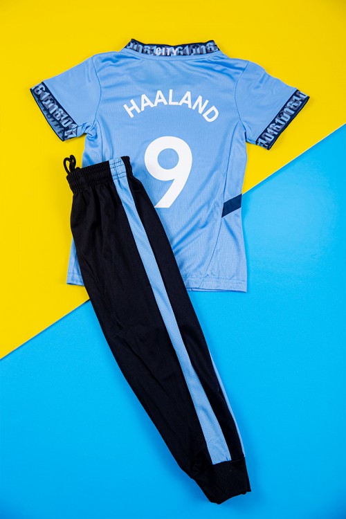 طقم ولادي رياضي قطعتين تيشيرت مانشستر سيتي بأكمام قصيرة و بنطلون طويل لون أسود مخطط باللون السماوي من الجانبين بزم من الخصر و الأسفل