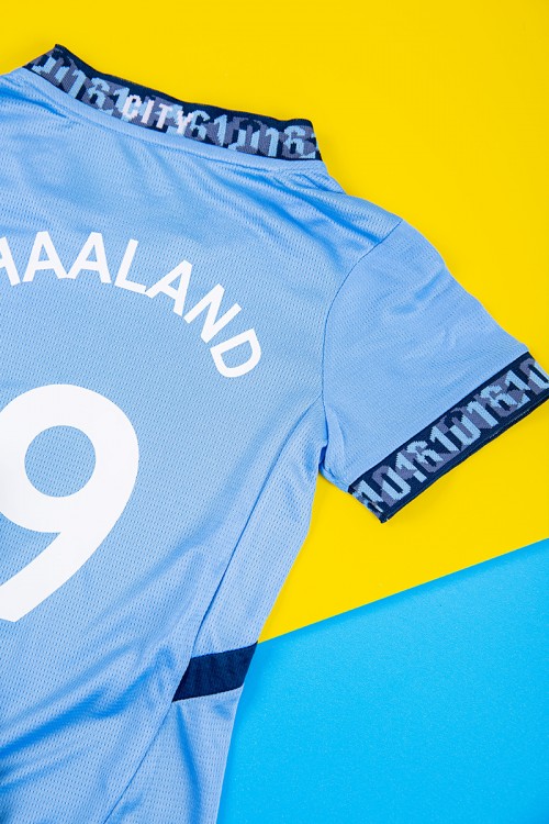 طقم ولادي رياضي قطعتين تيشيرت مانشستر سيتي بأكمام قصيرة و بنطلون طويل لون أسود مخطط باللون السماوي من الجانبين بزم من الخصر و الأسفل