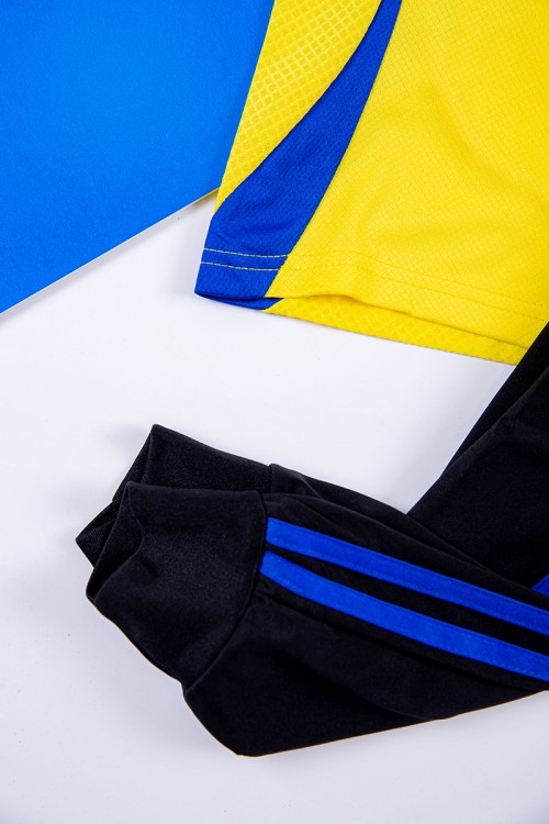 طقم ولادي رياضي قطعتين تيشيرت النصر لون أصفر بأكمام قصيرة و بنطلون طويل لون أسود مخطط باللون الأزرق من الجانبين بزم من الخصر و الأسفل