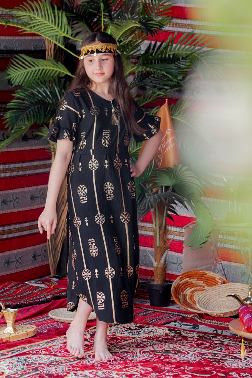 فستان بناتي لون أسود بأكمام قصيرة مزين بطبعات من شعار يوم التأسيس باللون الذهبي و رباط من الخصر