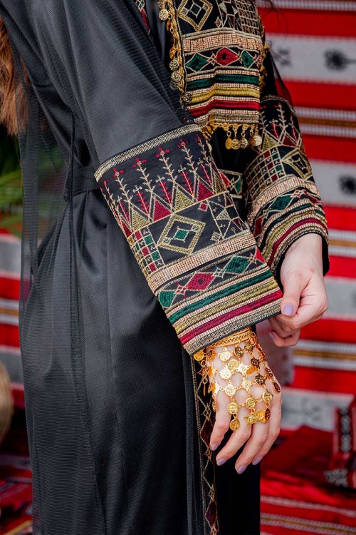 جلابية نسائية تراثية لون أسود بتطريز تراثي ملون من الأمام و الأكمام مزينة بجنيهات من الأمام و برباط في الخصر مع قماش شيفون من الخارج