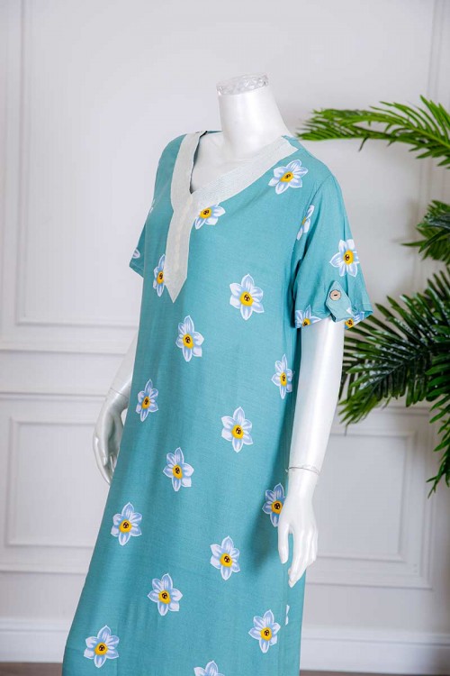 قميص نسائي طويل لون سماوي بطبعات ورود و بياقة كلفة مطرزة ذو أكمام قصيرة مزينة بأزرار