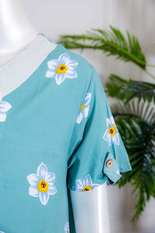 قميص نسائي طويل لون سماوي بطبعات ورود و بياقة كلفة مطرزة ذو أكمام قصيرة مزينة بأزرار