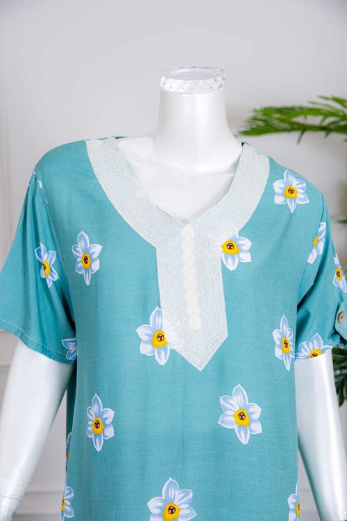 قميص نسائي طويل لون سماوي بطبعات ورود و بياقة كلفة مطرزة ذو أكمام قصيرة مزينة بأزرار