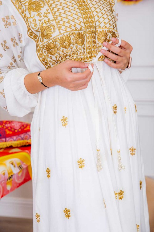 جلابية نسائية لون أبيض مزينة بتطريز ذهبي ذو أكمام طويلة و رباط على الخصر