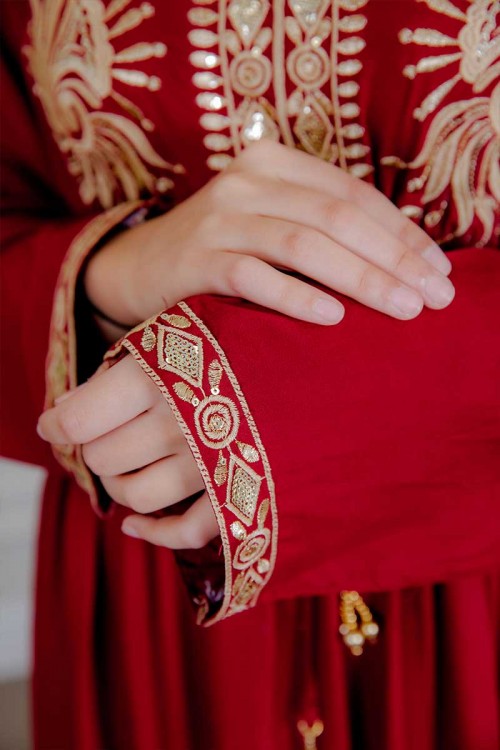 جلابية نسائية لون أحمر مزينة بتطريز ذهبي ذو أكمام طويلة و رباط على الخصر