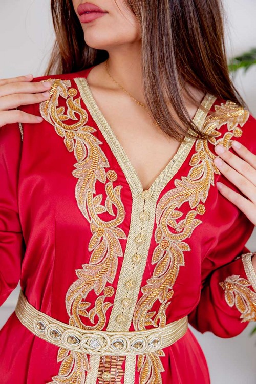 جلابية نسائية لون أحمر مزينة بتطريز ذهبي و بأزرار من الأمام و بحزام في الخصر مزين بفصوص من الاكسسوار