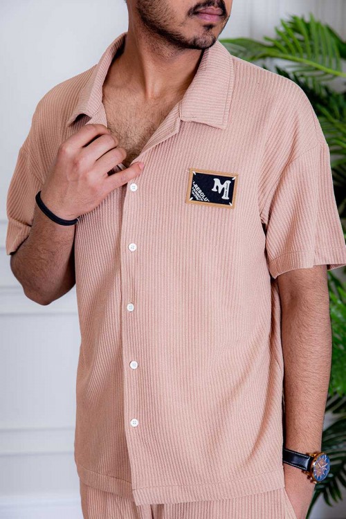 طقم رياضي رجالي بلوزة لون خربزي بياقة مطوية و أزرار و طبعات من الأمام و شورت لون خربزي بجيوب و رباط في الخصر