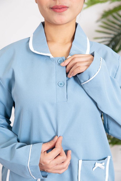 زي عاملة قطعتين لون سماوي بلوزة بياقة مطوية و أزرار و جيوب مزينة بفيونكة من الأمام  ذو أكمام طويلة و بنطلون طويل