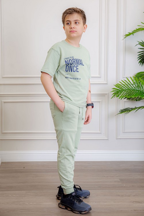 ترنج ولادي قطعتين لون تفاحي تيشيرت بكتابات من الأمام و الخلف و بنطلون بجيوب من الجانبين و الخلف و برباط في الخصر