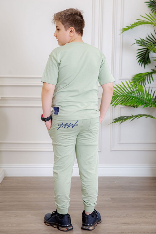 ترنج ولادي قطعتين لون تفاحي تيشيرت بكتابات من الأمام و الخلف و بنطلون بجيوب من الجانبين و الخلف و برباط في الخصر