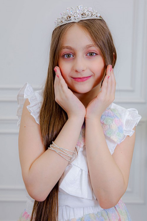 طقم تيور بناتي قطعتين بلوزة بلون أبيض مزينة بفيونكة ملونة من الأمام بدون أكمام و تـنورة ملونة