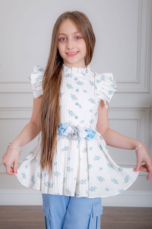 بدلة بناتي قطعتين بلوزة لون أبيض بياقة عالية بدون أكمام مزينة بورود سماوية و أزرار من الأمام و حزام في الخصر مع بنطلون طويل لون سماوي بجيوب من الجانبين