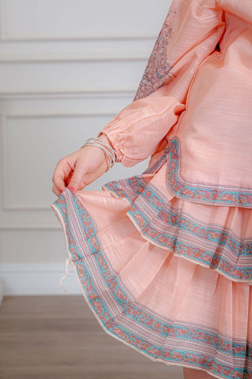 طقم تيور بناتي قطعتين لون خربزي بلوزة بياقة عالية و أزرار من الأمام ذو أكمام طويلة و تـنورة مزين بزخارف ملونة من الأطراف و الأكمام