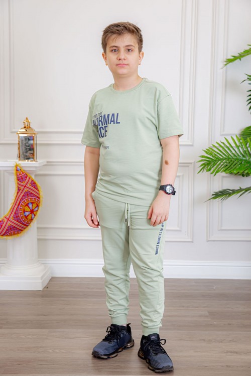 ترنج ولادي قطعتين لون تفاحي تيشيرت بكتابات من الأمام و الخلف و بنطلون بجيوب من الجانبين و الخلف و برباط في الخصر