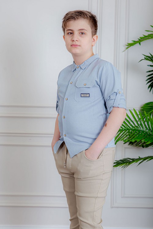 بدلة ولادي قطعتين قميص لون سماوي  بأزرار و جيب و كتابات من الأمام و بنطلون لون بيج بجيوب من الجانبين و الخلف و برباط في الخصر