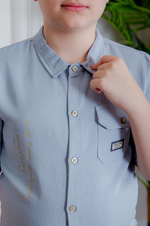 بدلة ولادي قطعتين قميص لون سماوي  بأزرار و جيب و كتابات من الأمام و بنطلون لون بيج بجيوب من الجانبين و الخلف و برباط في الخصر