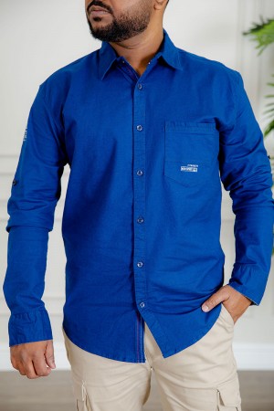 قميص رجالي لون أزرق كم طويل بأزرار من الأمام و الجانبين و بجيب من الأمام 
