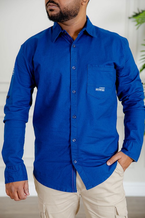 قميص رجالي لون أزرق كم طويل بأزرار من الأمام و الجانبين و بجيب من الأمام