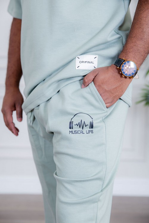 طقم رجالي قطعتين لون تيفاني فاتح تيشيرت بكتابات و طبعات مع بنطلون طويل بجيوب من الجانبين و الخلف و برباط في الخصر