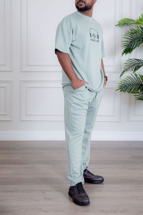 طقم رجالي قطعتين لون تيفاني فاتح تيشيرت بكتابات و طبعات مع بنطلون طويل بجيوب من الجانبين و الخلف و برباط في الخصر