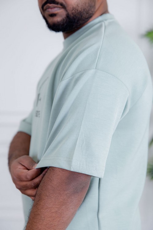 طقم رجالي قطعتين لون تيفاني فاتح تيشيرت بكتابات و طبعات مع بنطلون طويل بجيوب من الجانبين و الخلف و برباط في الخصر