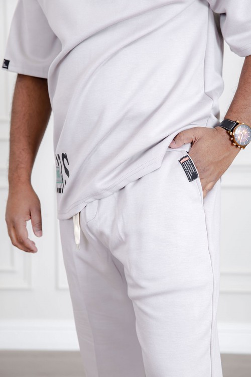 طقم رجالي قطعتين لون أبيض تيشيرت بكتابات مع بنطلون طويل بجيوب من الجانبين و الخلف و برباط في الخصر