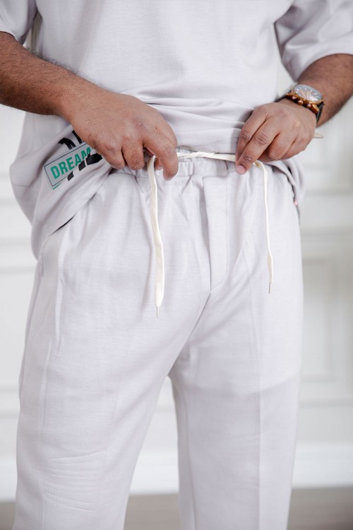 طقم رجالي قطعتين لون أبيض تيشيرت بكتابات مع بنطلون طويل بجيوب من الجانبين و الخلف و برباط في الخصر