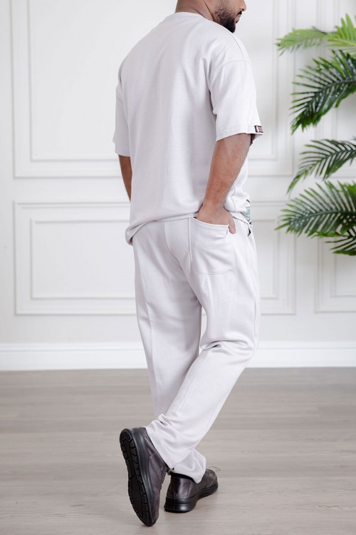 طقم رجالي قطعتين لون أبيض تيشيرت بكتابات مع بنطلون طويل بجيوب من الجانبين و الخلف و برباط في الخصر