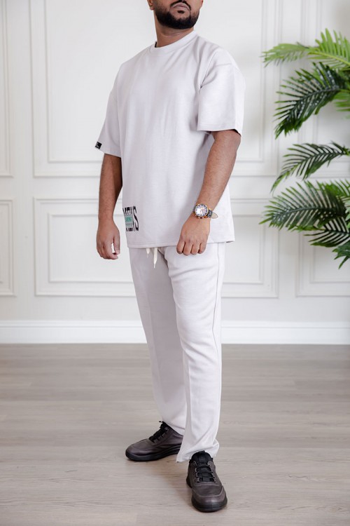 طقم رجالي قطعتين لون أبيض تيشيرت بكتابات مع بنطلون طويل بجيوب من الجانبين و الخلف و برباط في الخصر
