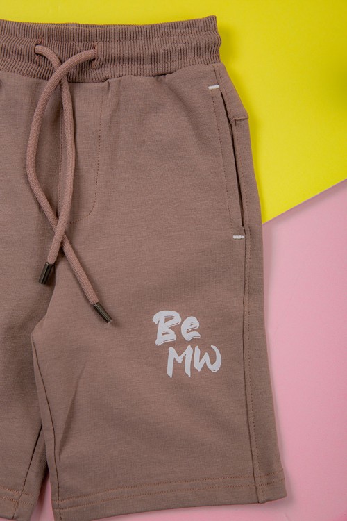 ترنج ولادي قطعتين لون لحمي تيشيرت برسومات و كتابات من الأمام و شورت برباط في الخصر و جيوب من الجانبين و الخلف