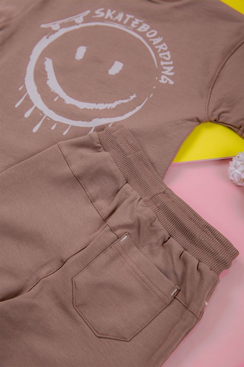 ترنج ولادي قطعتين لون لحمي تيشيرت برسومات و كتابات من الأمام و شورت برباط في الخصر و جيوب من الجانبين و الخلف