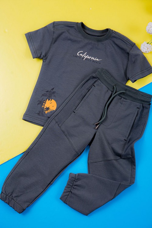 ترنج ولادي قطعتين لون كحلي تيشيرت بكتابات ورسومات من الأمام و بنطلون طويل برباط في الخصر و جيوب من الجانبين و الخلف