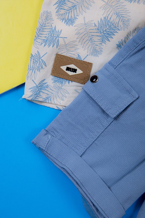 طقم ولادي قطعتين قميص أبيض مشجر باللون السماوي ياقة مطوية و أزرار من الأمام و شورت لون سماوي برباط في الخصر و جيوب من الجانبين