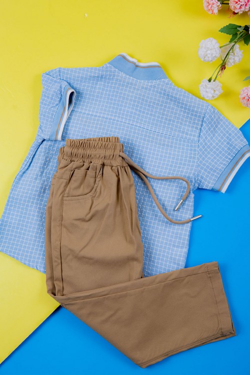 طقم ولادي قطعتين قميص سماوي مربعات بكتابات و جيبوب و أزرار من الأمام و بنطلون لون بيج غامق برباط في الخصر و جيوب من الجانبين