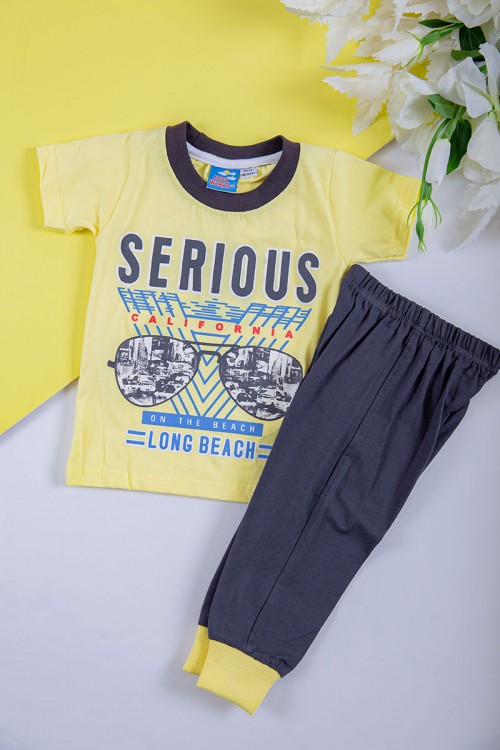 طقم ولادي قطعتين تيشيرت لون أصفر مزين بكتابات و رسومات من الأمام مع بنطلون طويل لون رصاصي بزم في الأسفل